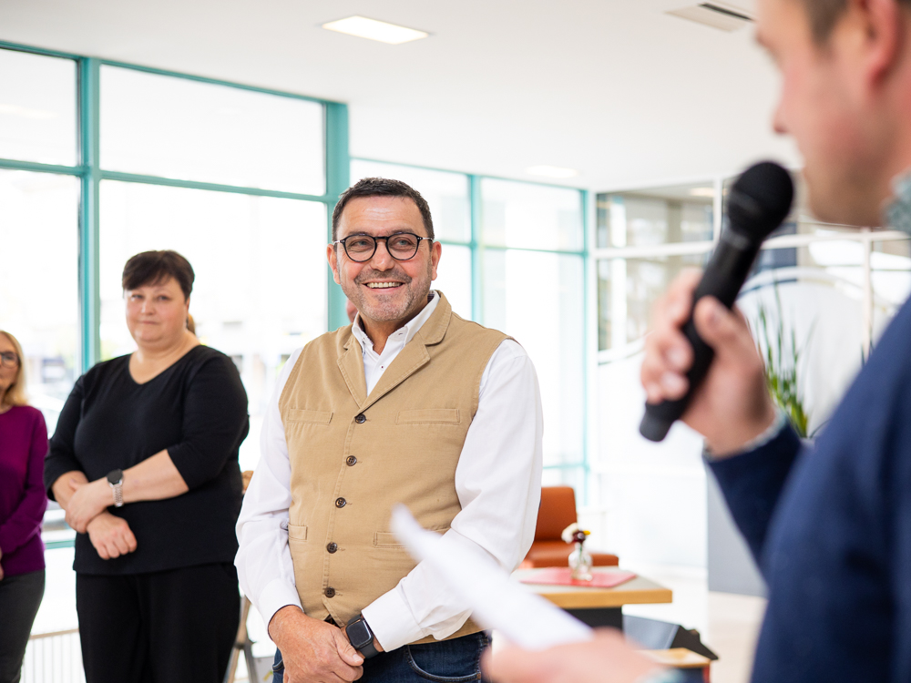 Peter Witt lächelt, während er der Rede von Hendrik Kleinbecker zuhört