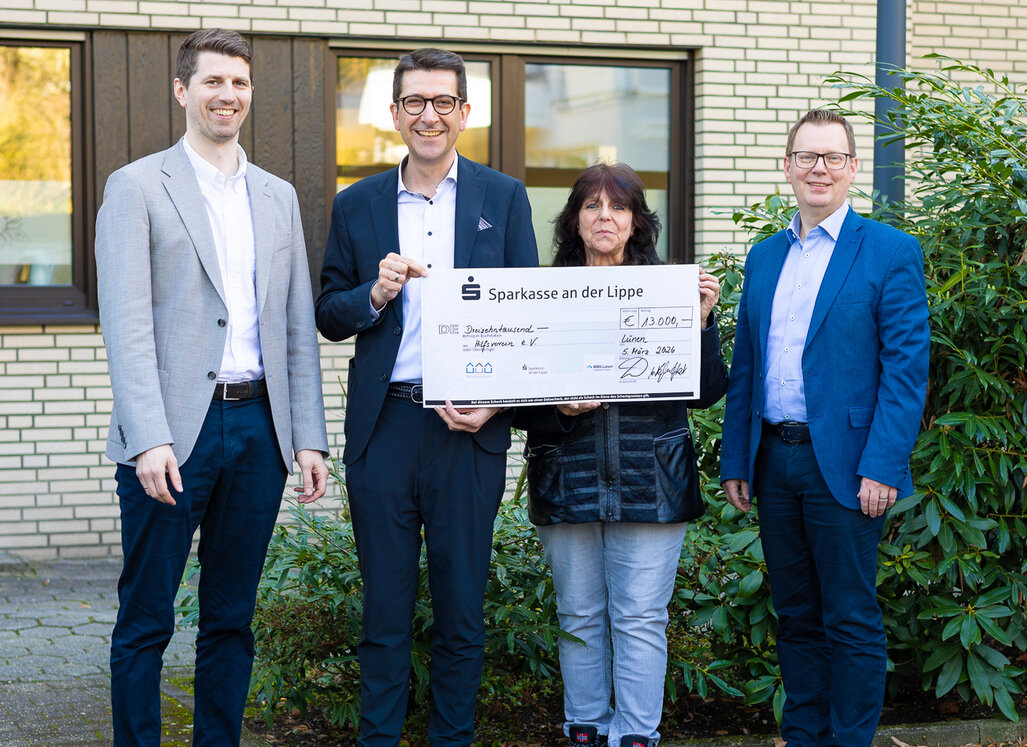 Jan Hische, Heiko Rautert, Silke Kühn und Stephan Heupel stehen nebeneinander und halten den Spendencheck in ihren Händen. Sie lächeln in die Kamera.