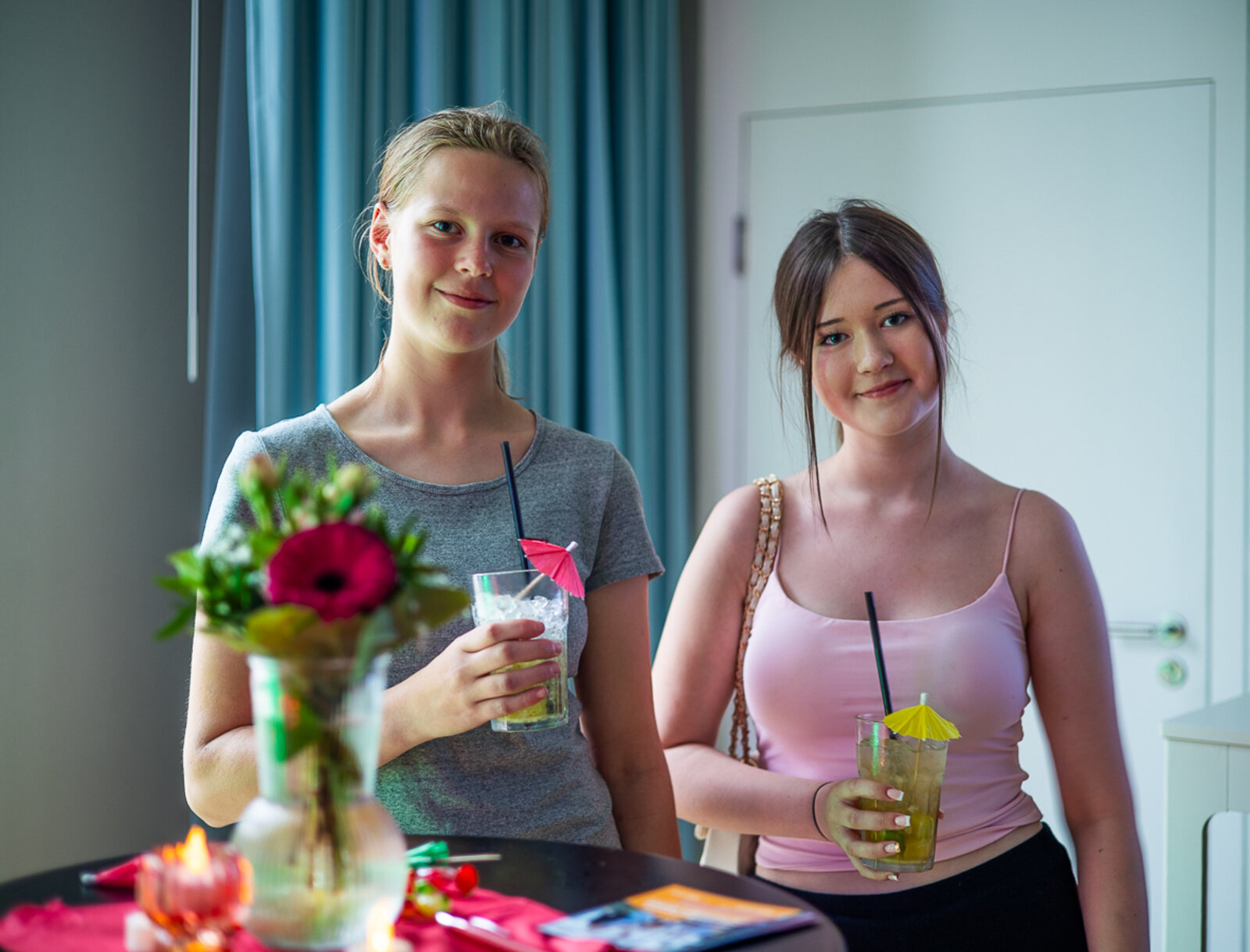 Zwei junge Frauen stehen mit einem Cocktail im Veranstaltungsbereich der Lüner Nacht der Ausbildung.