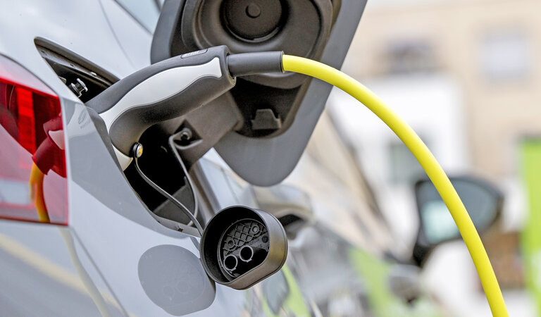 Frauke Schumann Nahaufnahme eines Elektroautos beim Laden an einer Ladesäule.