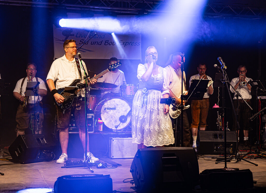 Die Band Ski und Bob Express spielt mit Gesang, Gitarren und Blasinstrumenten auf der Bühne.