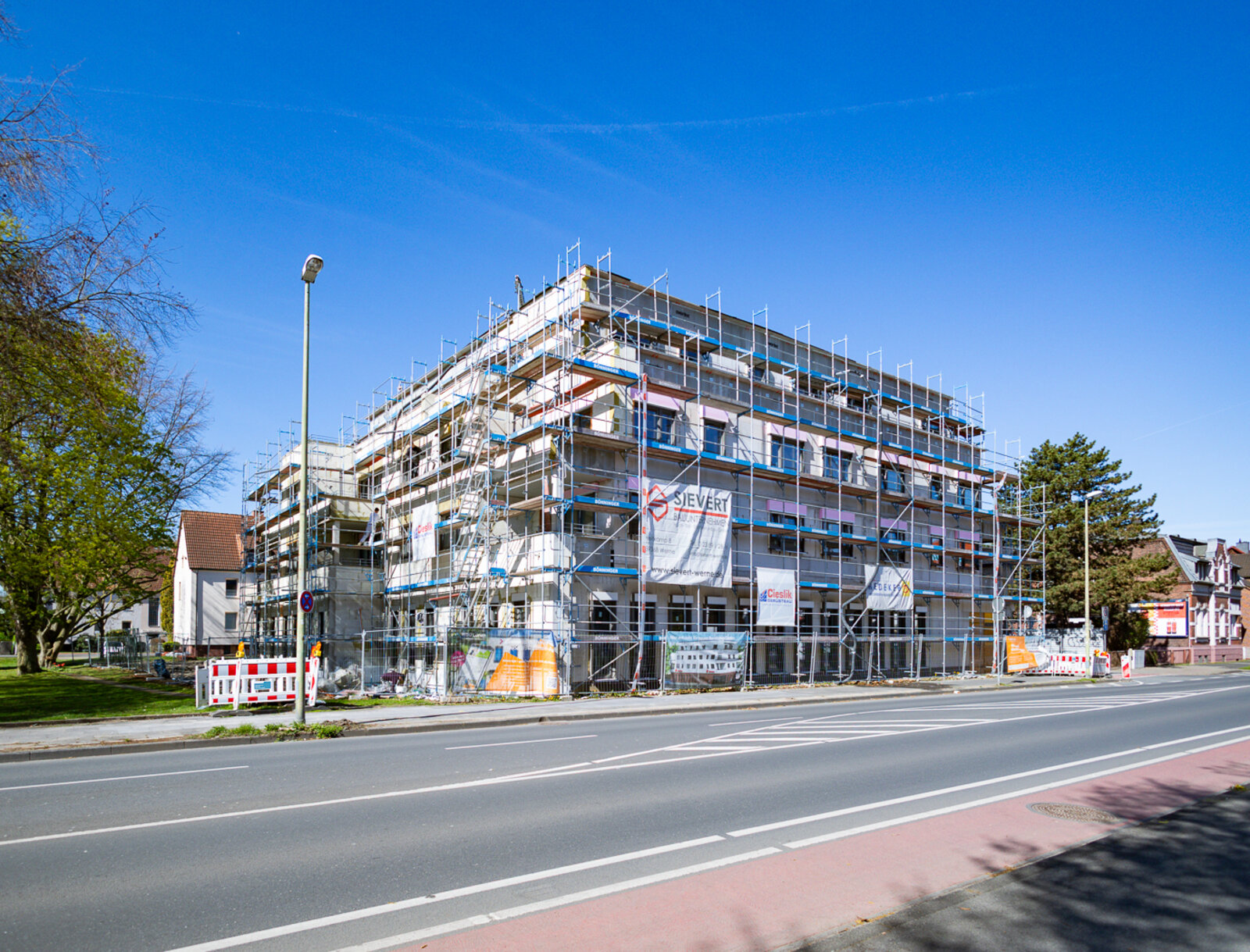 Mehrgeschossiger Neubau eines Mehrfamilienhauses mit Gewerbeflächen im Erdgeschoss.