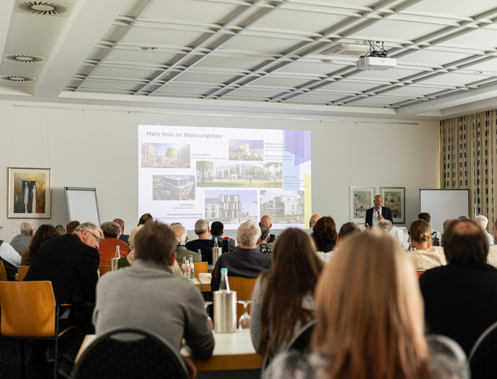 Teilnehmende des Vertreter*innenseminars verfolgen einen Vortrag im Tagungsraum mit Präsentation.