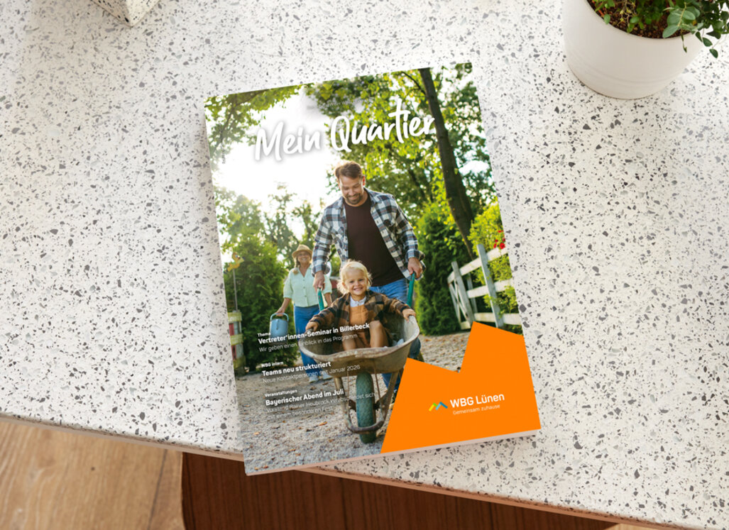 Ausgabe des Magazins „Mein Quartier“ der WBG Lünen liegt auf einer Tischoberfläche. Auf dem Titel ist eine Familie im Grünen zu sehen.