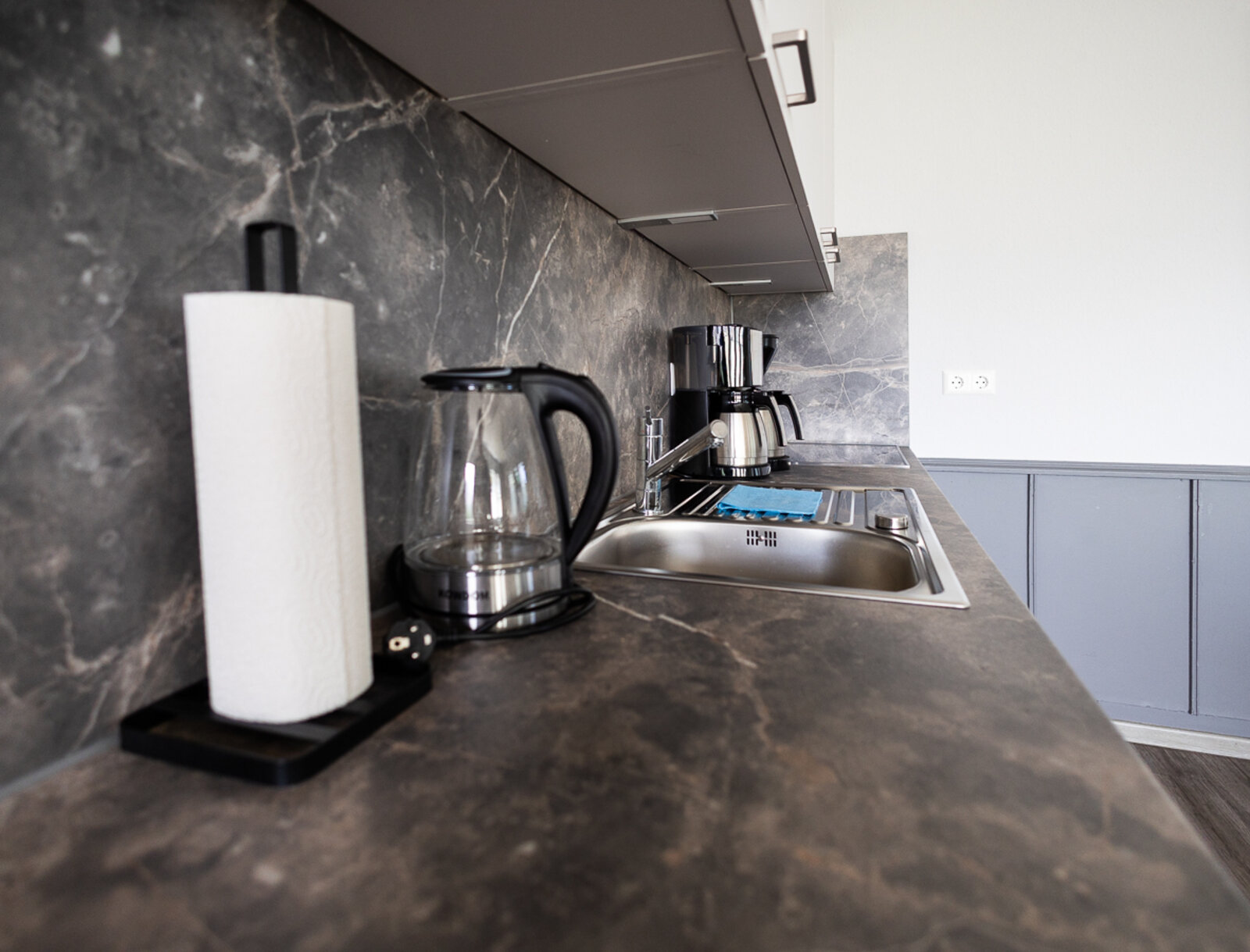 Arbeitsplatte der neuen Küche im Gemeinschaftsraum mit Spüle, Wasserkocher und Kaffeemaschine.