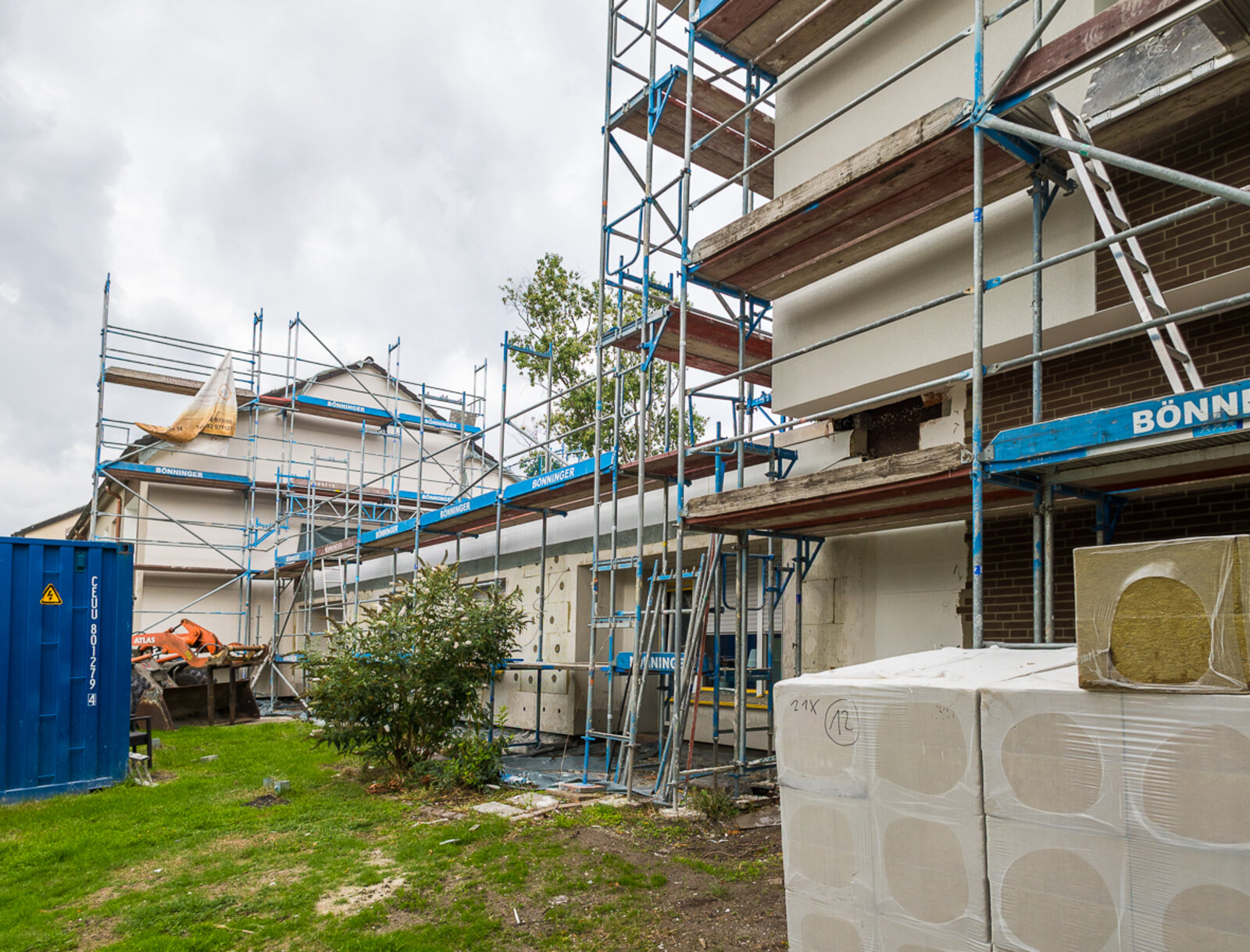 Wohngebäude mit davor platzierten Baumaterialien in der Wilhelm-Löbbe-Allee während der Fassadenmodernisierung