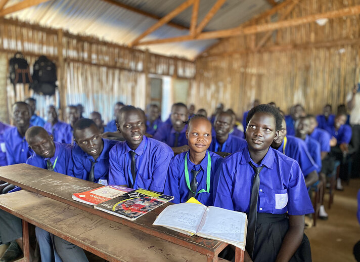Schulmädchen in Tansania sitzen in ihrem Klassenraum und schauen in die Kamera