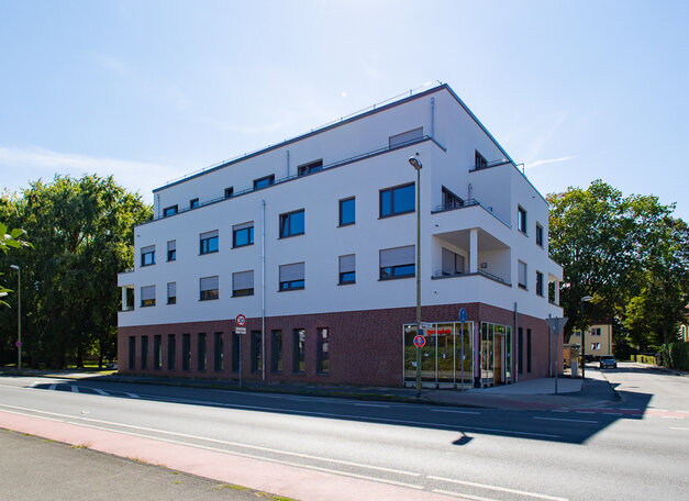 Mehrfamilienhaus im Bau mit Gewerbeflächen im Erdgeschoss.