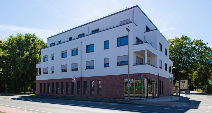 Mehrfamilienhaus im Bau mit Gewerbeflächen im Erdgeschoss.