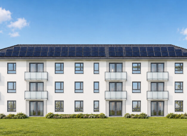 Südansicht des Mehrfamilienhauses mit Balkonen und Photovoltaikanlage auf dem Dach.
