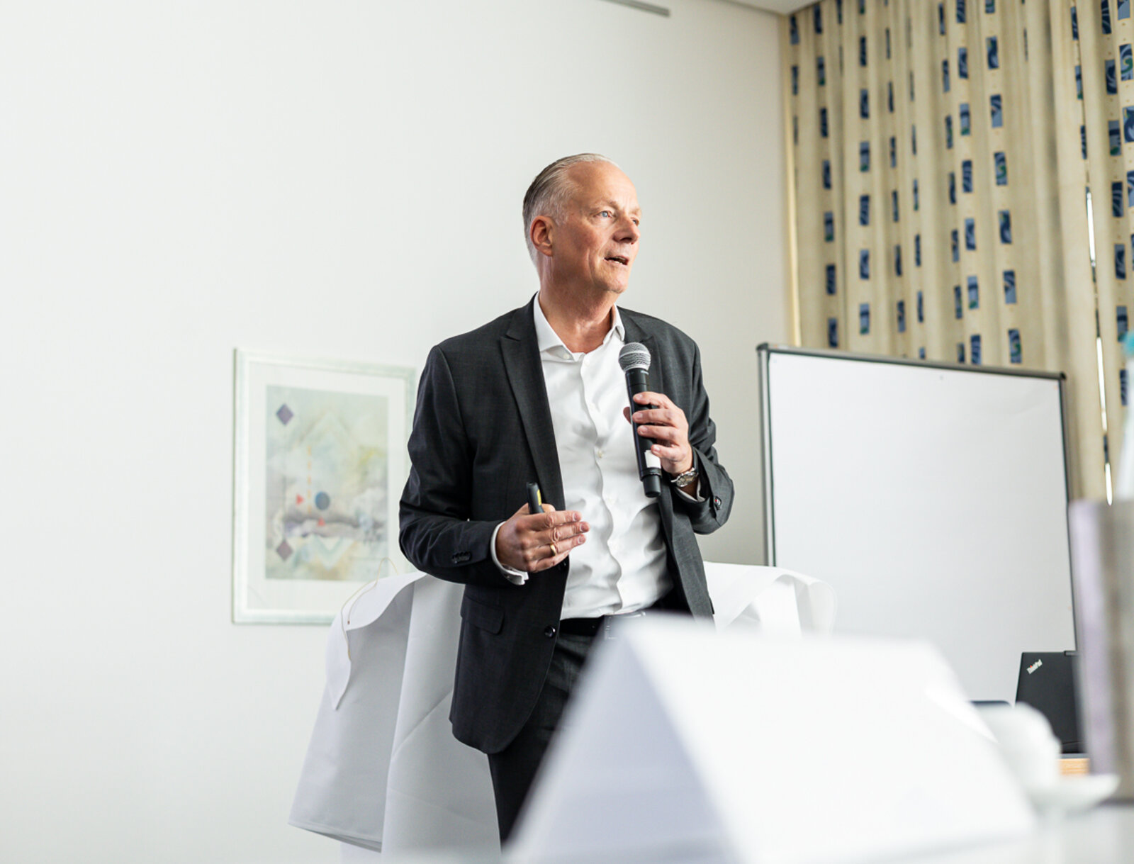 Alexander Rychter hält einen Vortrag bei einem Vertreter*innenseminar in Billerbeck und spricht mit Mikrofon vor den Teilnehmenden.