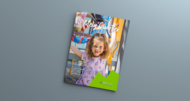 Das Mitgliedermagazin liegt auf einem grauen Hintergrund. Auf dem Cover ein Mädchen zu sehen, dass in die Kamera lächelt. Im Hintergrund ist ein Spielplatz zu sehen.