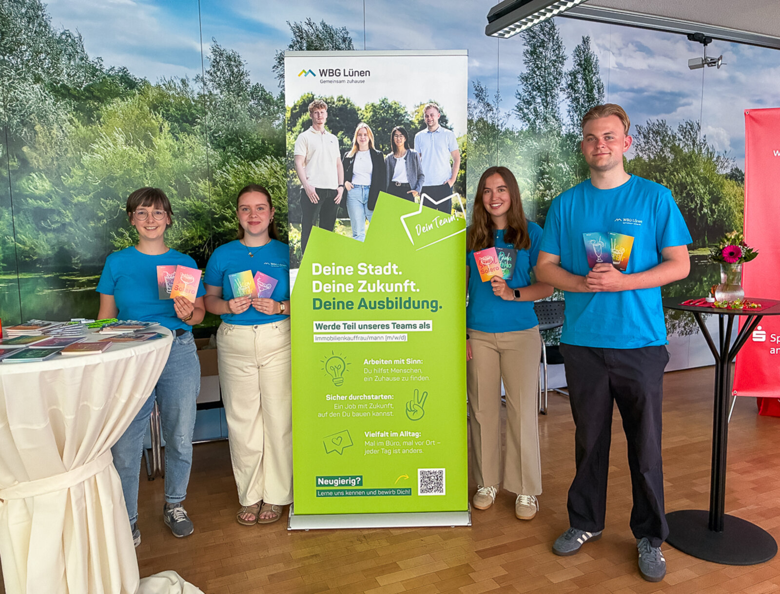 Das Team der WBG Lünen präsentiert den Informationsstand bei der Lüner Nacht der Ausbildung und lächeln freundlich in die Kamera.