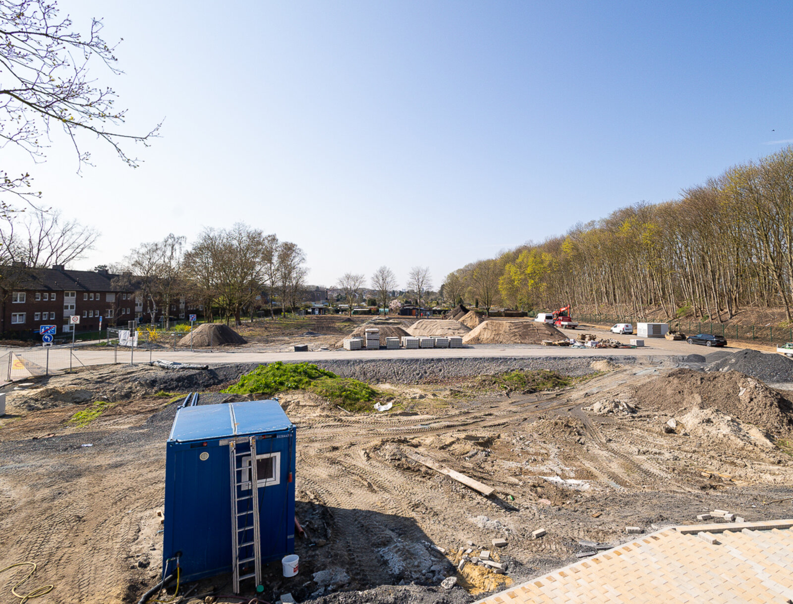 Blick über das Baugelände des Neubauprojekts mit vorbereiteten Erdarbeiten, Baustraßen und Lagerflächen zu Beginn der Bauphase.