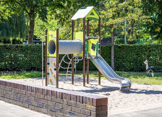 Neues Kletter- und Rutschgerät auf dem teilmodernisierten Spielplatz im Quartier „Am Stierksken“ in Selm-Cappenberg. Das Spielgerät steht in einem Sandbereich und ist von Bäumen und Grünflächen umgeben.