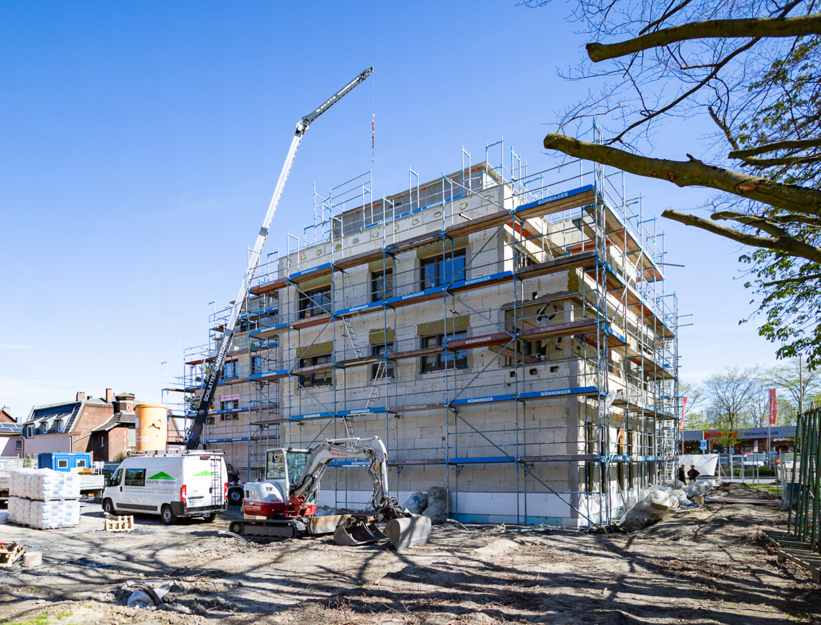 Mehrgeschossiger Neubau eines Mehrfamilienhauses mit Gewerbeflächen im Erdgeschoss.