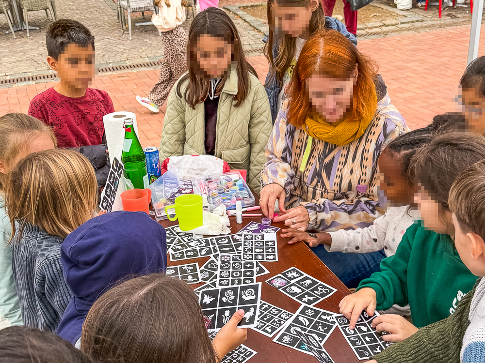 Kinder suchen sich Glitzertattoos aus